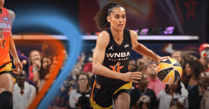 WNBA All-Star player dibbles the basketball during All-Star Game with fans in the background